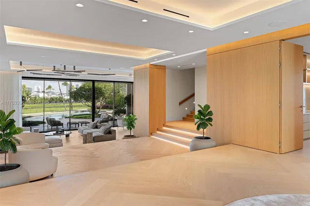 a living room with furniture a chandelier and a floor to ceiling window