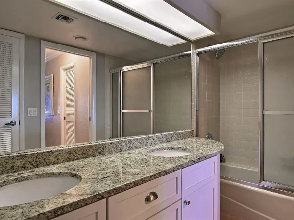 a bathroom with a granite countertop sink and a mirror
