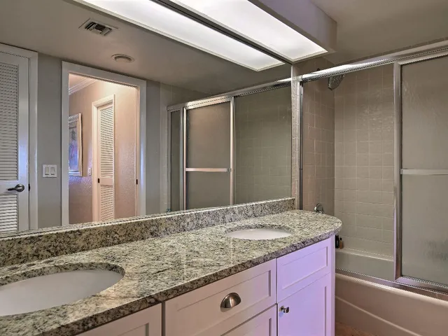 a bathroom with a granite countertop sink and a mirror
