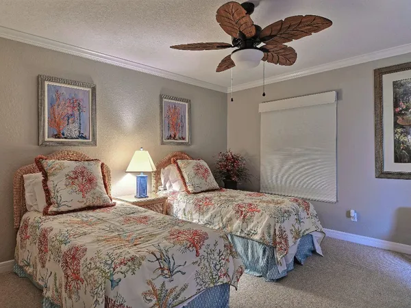 a bedroom with two beds and a chandelier
