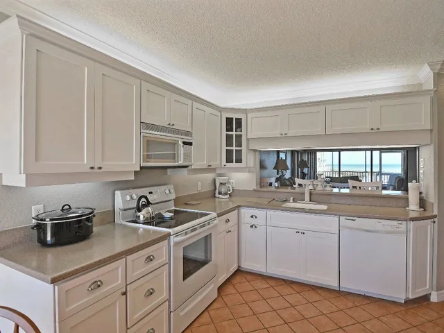 a kitchen with white cabinets sink and appliances