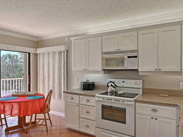 a kitchen with stainless steel appliances granite countertop a stove a sink a dining table and chairs