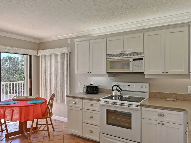 a kitchen with stainless steel appliances granite countertop a stove a sink a dining table and chairs