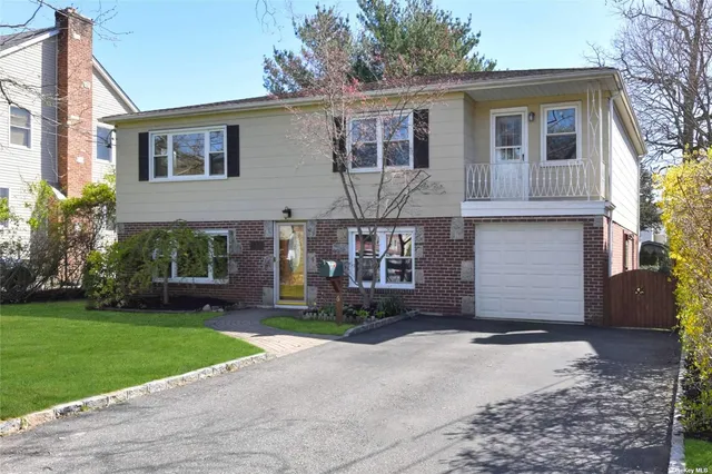 a front view of house with yard and trees around