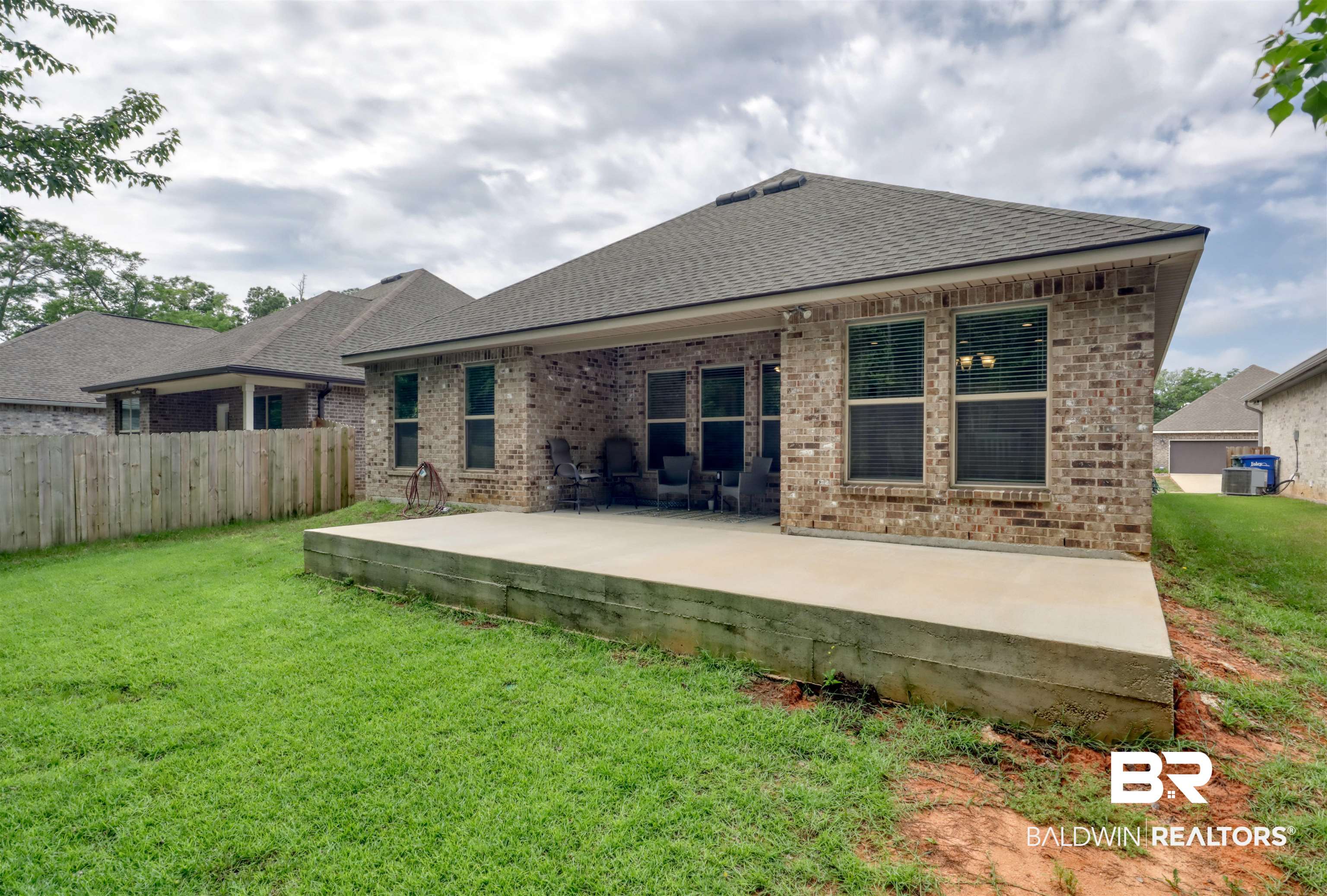 987 Gibson Court Foley, AL 36535 - Photo 32 of 34 Back of house featuring brick siding, fence, a yard, a patio, and a shingled roof