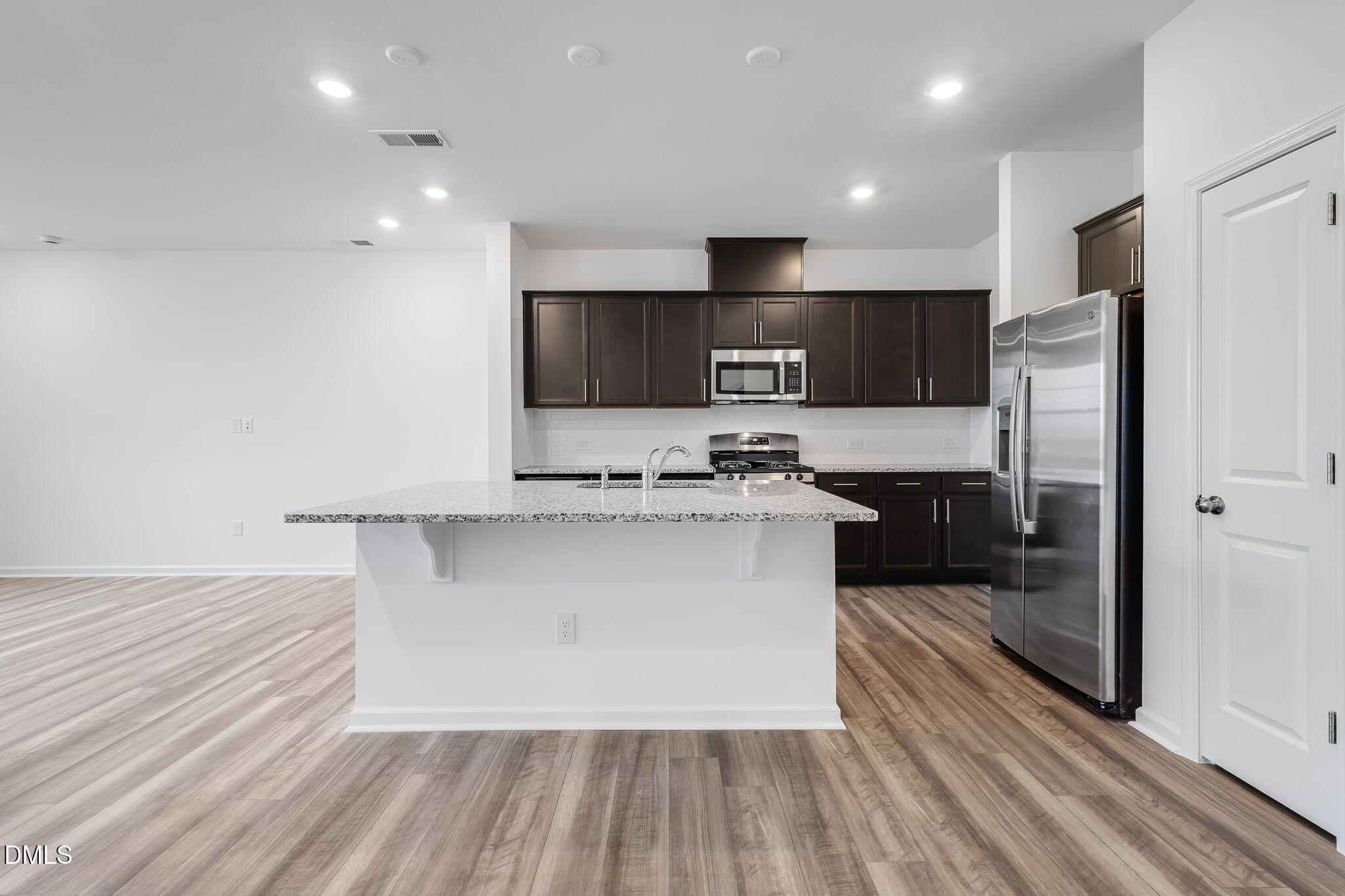 2939 Hickory Fld Drive Raleigh, NC 27616 - Photo 12 of 30 a large kitchen with stainless steel appliances a large counter top a stove a refrigerator and a cabinets
