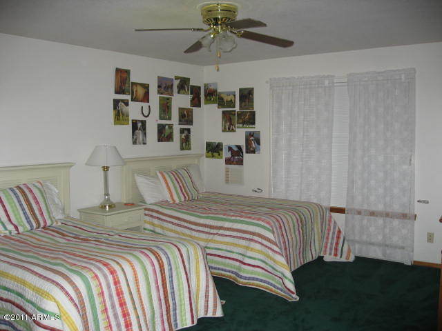 2935 Deer Hill Road Heber, AZ 85928 - Photo 11 of 14 a bedroom with a bed and a chandelier
