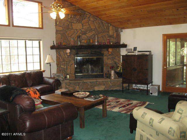 2935 Deer Hill Road Heber, AZ 85928 - Photo 4 of 14 a living room with furniture a flat screen tv and a fireplace