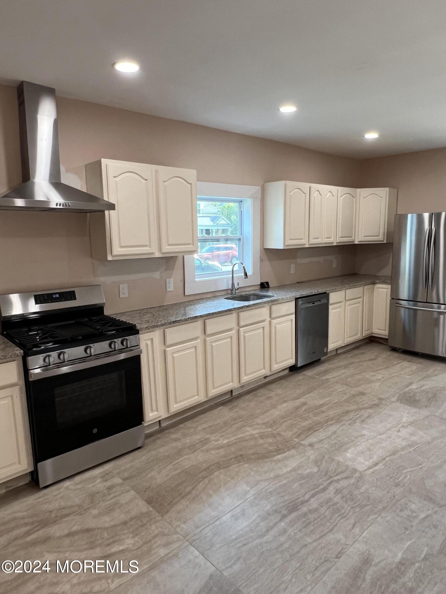815 Clark Street, Unit 1 Point Pleasant, NJ 08742 - Photo 4 of 10 a kitchen with stainless steel appliances granite countertop a stove a sink and a refrigerator