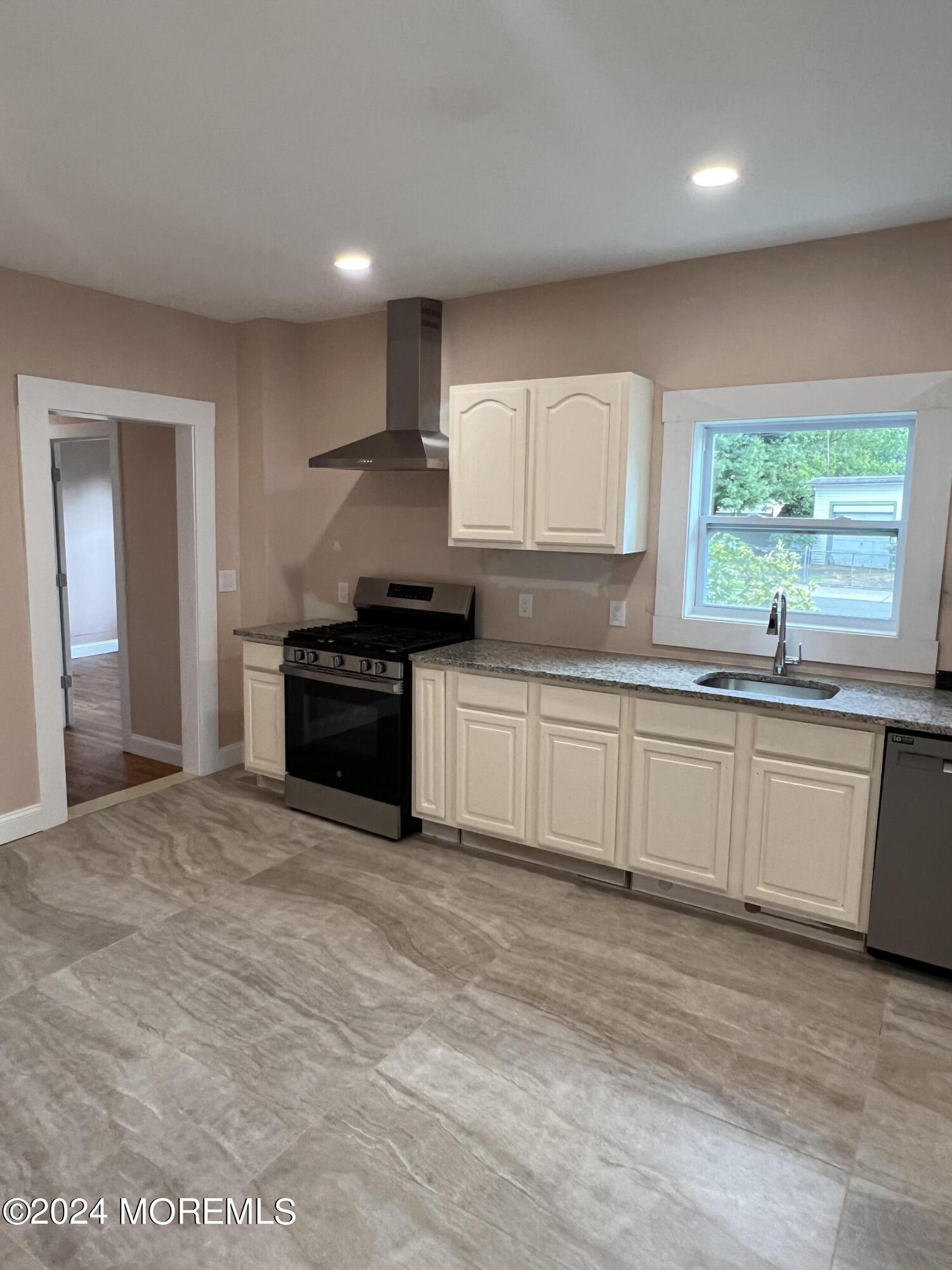 815 Clark Street, Unit 1 Point Pleasant, NJ 08742 - Photo 5 of 10 a kitchen with stainless steel appliances granite countertop a stove a sink and a granite counter tops