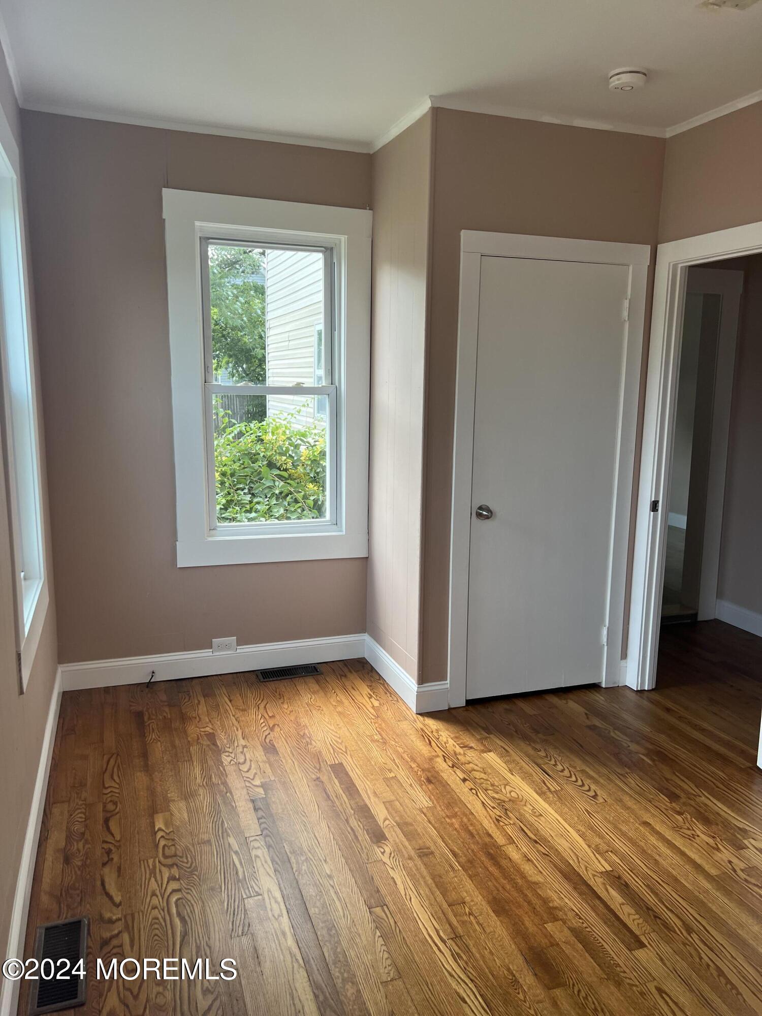 815 Clark Street, Unit 1 Point Pleasant, NJ 08742 - Photo 8 of 10 a view of an empty room with wooden floor and a window