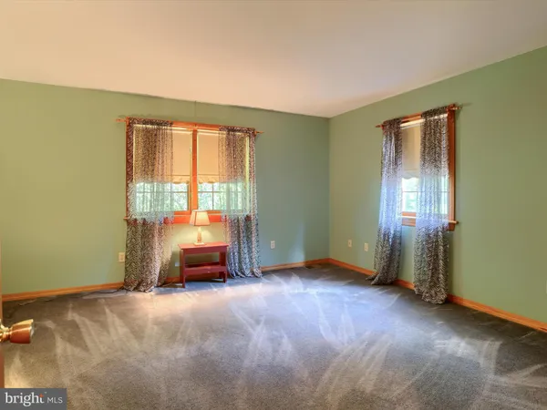 an empty room with wooden floor and closet area