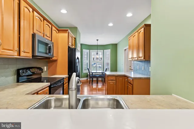 a kitchen with stainless steel appliances granite countertop a refrigerator a stove top oven a sink and dishwasher