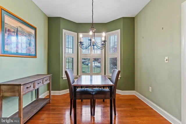 a dining room with furniture a chandelier and wooden floor