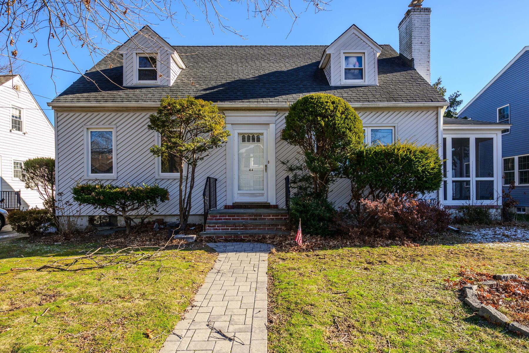 Cape cod house featuring a sunroom and a front yard