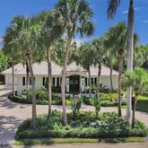 a front view of a house with garden and trees