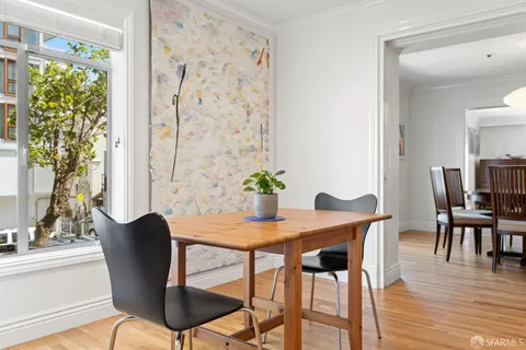 a dining room with furniture potted plants and wooden floor