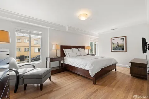 a bedroom with a bed wooden floor and lamp