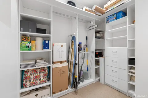 a view of walk in closet with clothes and shoes