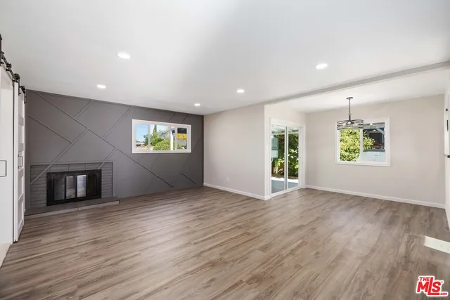 an empty room with windows and fireplace