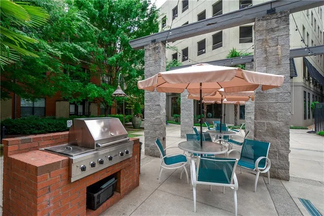 a view of a patio with table and chairs under an umbrella