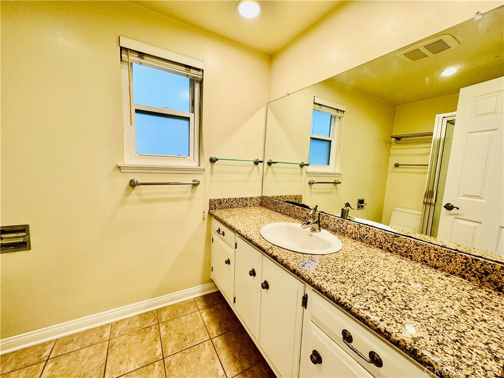 3632 Myrtle Street Irvine, CA 92606 - Photo 16 of 40 a bathroom with a granite countertop sink and a mirror
