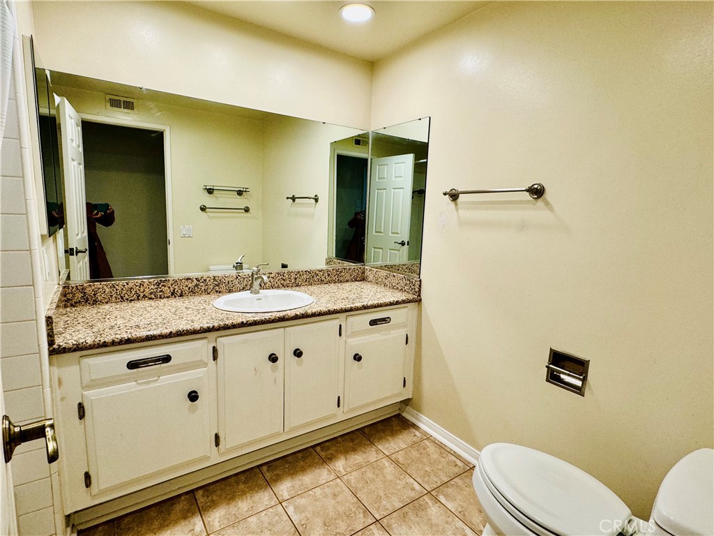 3632 Myrtle Street Irvine, CA 92606 - Photo 21 of 40 a bathroom with a granite countertop toilet sink and mirror