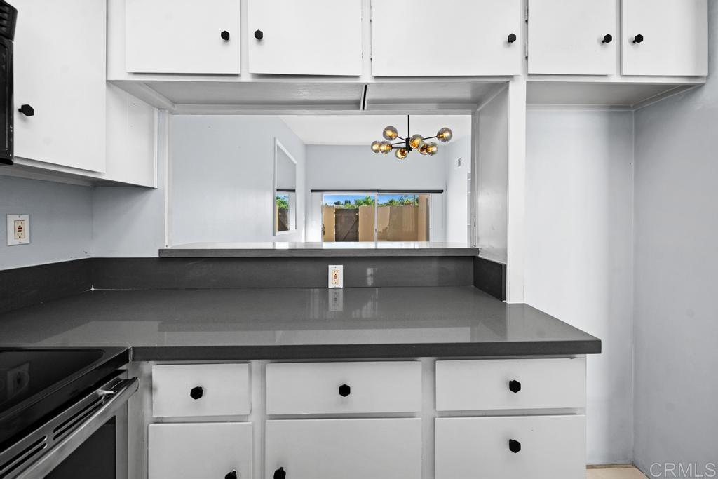 12228 Rancho Bernardo Road, Unit B San Diego, CA 92128 - Photo 7 of 35 a kitchen with stainless steel appliances a sink and cabinets