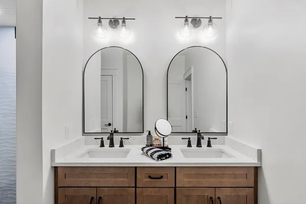a bathroom with double vanity sinks and a mirror