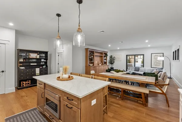 a view of a kitchen with kitchen island a dining table and chairs