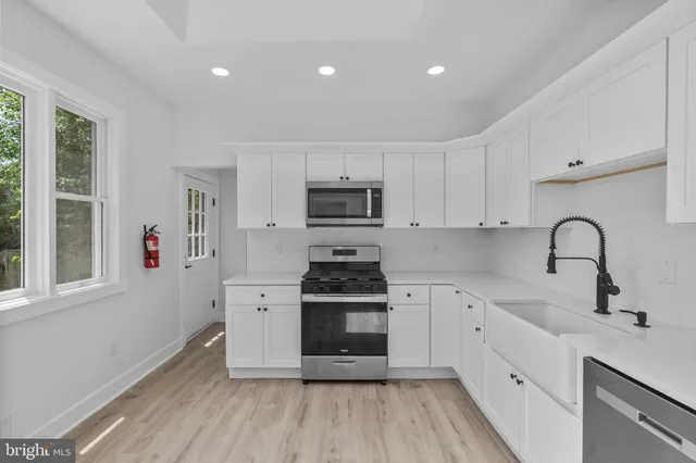 a kitchen with stainless steel appliances a stove sink and cabinets
