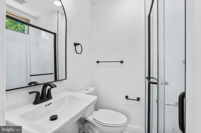 a bathroom with a sink a toilet and a mirror