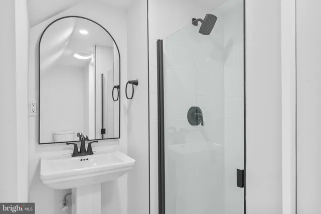a bathroom with a mirror a sink and shower