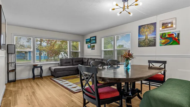 a view of a dining room with furniture a rug and wooden floor