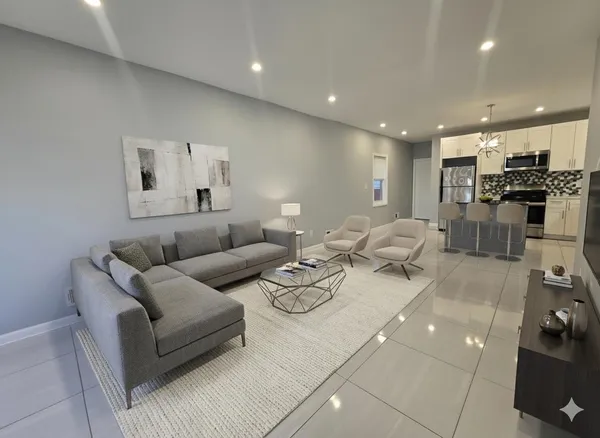 a living room with furniture and kitchen view