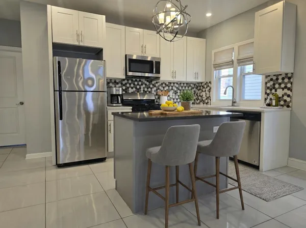 a kitchen with stainless steel appliances granite countertop a refrigerator and a stove top oven