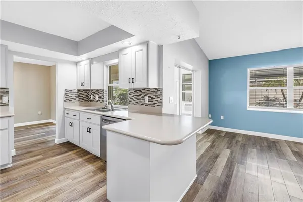 a kitchen with stainless steel appliances cabinets and wooden floor