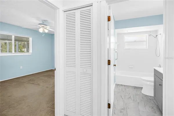 an empty room with a ceiling fan and a window