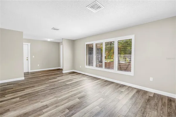 a view of a room with wooden floor and window