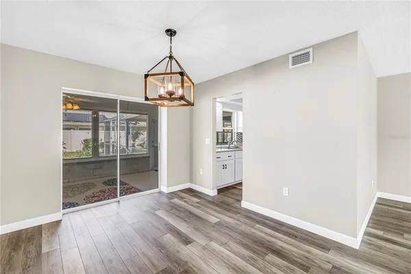 a view of wooden floor and a chandelier in a room