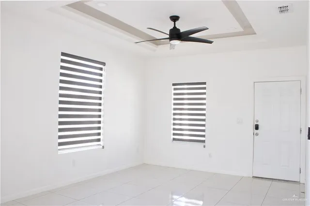 a large kitchen with a refrigerator and white cabinets
