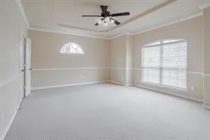 an empty room with windows and chandelier fan