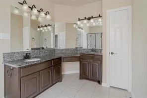 a bathroom with a granite countertop sink a large mirror and a shower