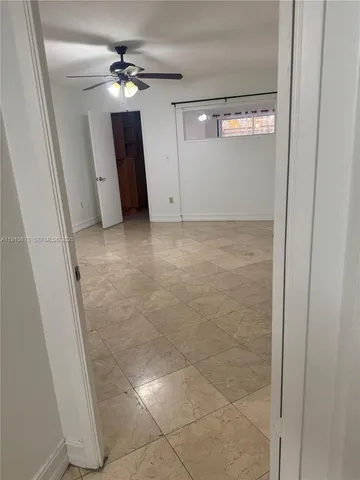 a view of an empty room with a chandelier fan