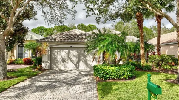 a front view of a house with a yard and potted plants