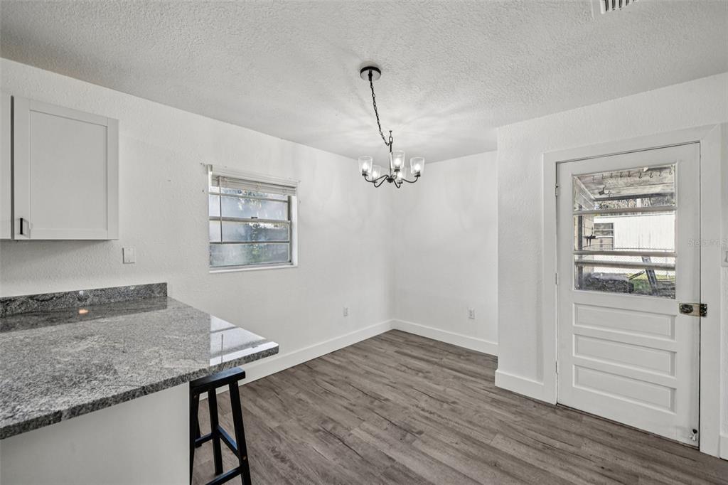 56305 Redbud Road Astor, FL 32102 - Photo 15 of 32 a room with a wooden floor and chandelier