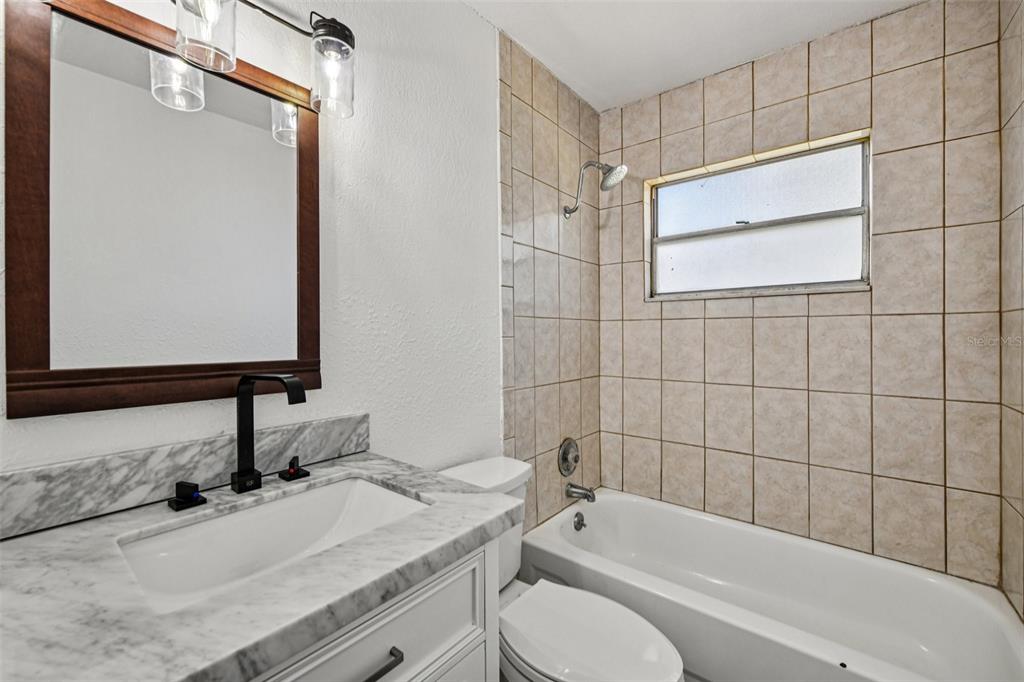 56305 Redbud Road Astor, FL 32102 - Photo 19 of 32 a bathroom with a granite countertop sink toilet and shower