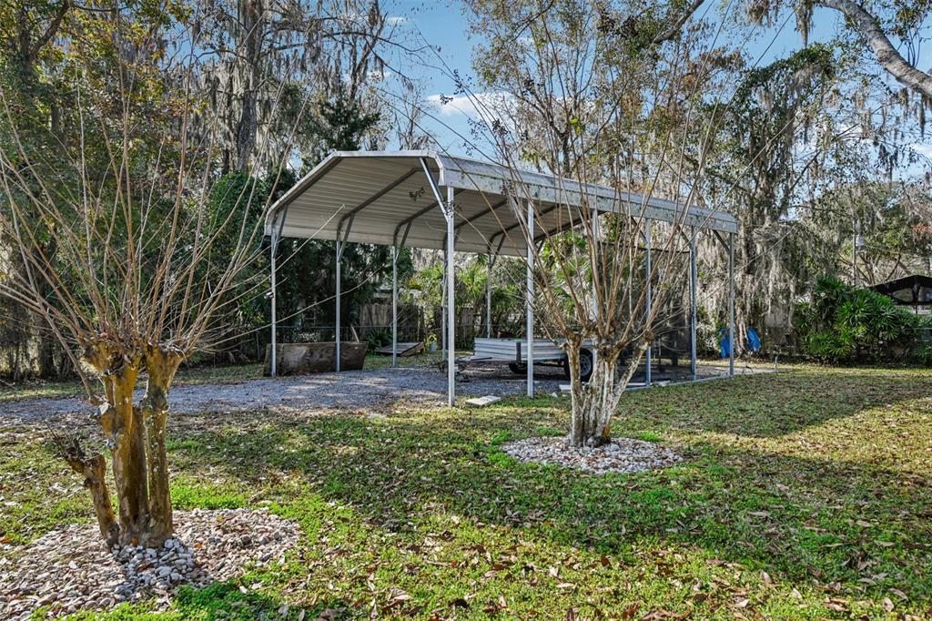 56305 Redbud Road Astor, FL 32102 - Photo 28 of 32 a backyard of a house with barbeque oven