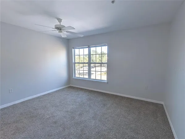 a view of an empty room with a chandelier fan