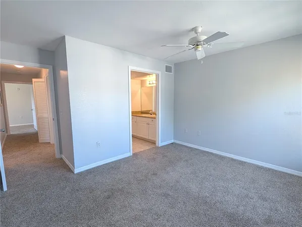 an empty room with a ceiling fan and a window